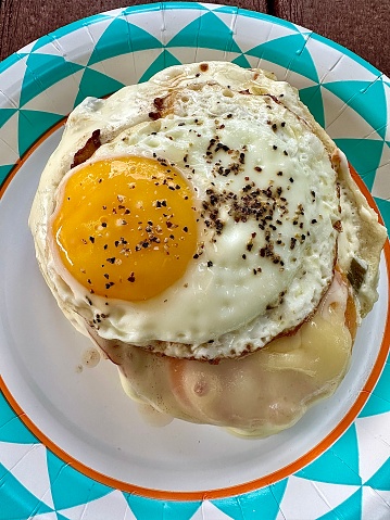 Loaded bagel melt breakfast sandwich with an egg, tomato, ham, jalapeño cream cheese.
