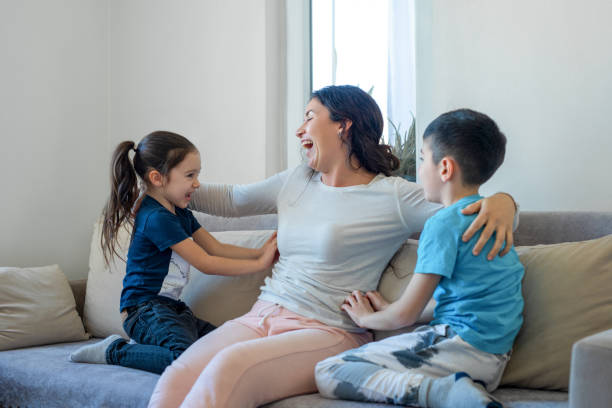 istock Mother having fun with two kids at home, tickling 1482826612