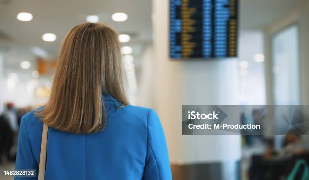 Woman In Business Suit In Checking Her Flight In Airport Stock Photo - Download Image Now