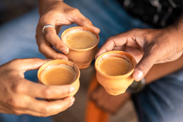 Clay tea cup being hold in the hand Tea or chai served in earthen cup or khulhad, Three cups of tea with milk tea. cup of tea hands stock pictures, royalty-free photos & images