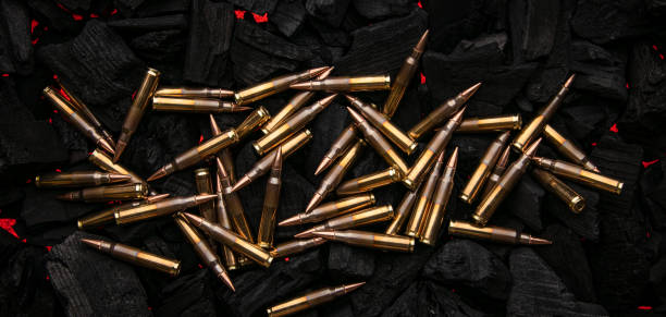 istock Cartridges for automatic carbine caliber .223 on charcoal. Ammunition for automatic and semi-automatic rifles. Dark background. 1482828764