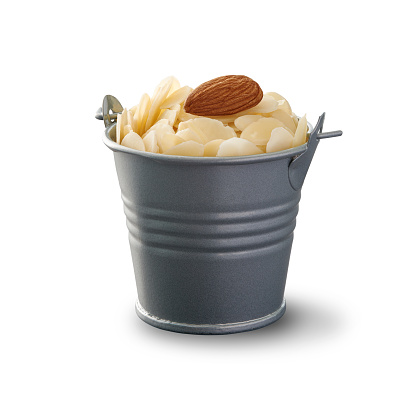 Almond flakes in a small metal bucket. Front view. Isolated on white background.