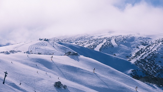 Snow-covered mountain slope with a stunning view of snow-dusted hills in the background.