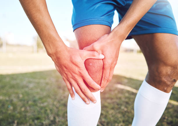 blessure au genou, douleur rouge et mains sur le terrain de sport ou de football pour la compétition, l’entraînement et l’exercice problème avec superposition. soccer, conditionnement physique et jambes d’athlète ou d’homme en cas d’urgence m - foot massage photos et images de collection