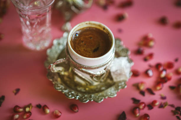 A close-up view of a cup of Turkish coffee with a vibrant pink background and candy decorations. The rich aroma and captivating presentation make this colorful scene the perfect way to enjoy a traditional Turkish beverage.