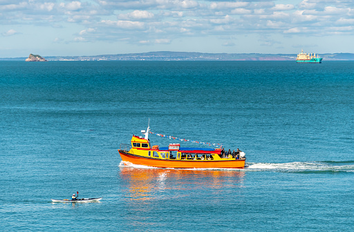 Brixham, UK. 15 April 2023. People on a Passenger ferry at sea near Brixham, with a kayak in the foreground.