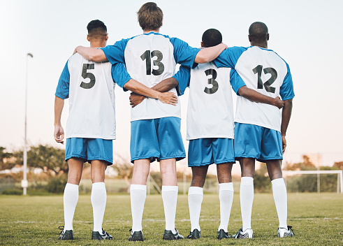 Soccer, team and hug standing with back on the field in partnership, trust or ready for sports game or match. Sport men hugging in teamwork, collaboration or unity for fitness, training or workout