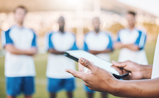 Football, soccer and team statistics on a tablet and coach analysis online, internet or website on a sports field. Teamwork, digital and tactics by modern trainer tracking performance analytics