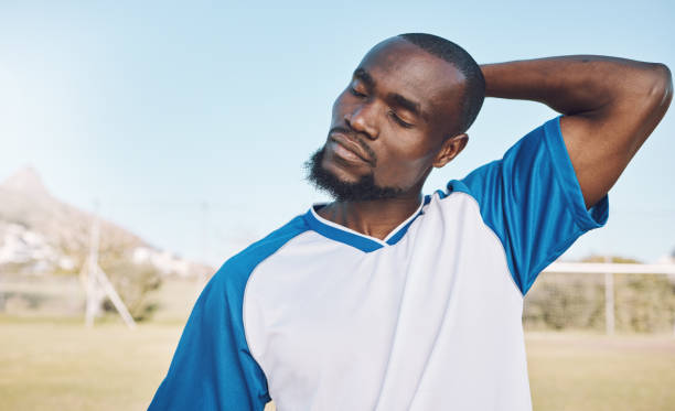 istock Soccer, black man and stretching before game, training or exercise for wellness, preparation for match or energy. African American male athlete, guy or football player stretch neck, fitness or sports 1482840677