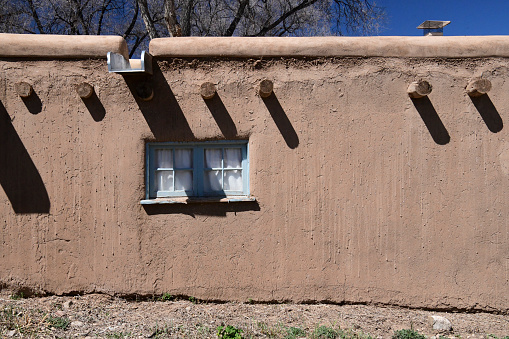Taos NM, USA -April 15, 2023: The Southwest of the US is home to some very unique architecture. Local materials  and adobe building style characterize the majority of the building in the Southwest. The image was captured near  the old town plaza in Taos, New Mexico and shows a one story adobe structure.