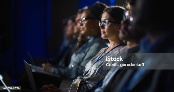 Young Psychologist Attending An International Cognitive Behavioral Therapy Seminar Specialist Using Laptop Computer Psychotherapy Professional Sitting In A Crowded Room On A Training Program Stock Photo - Download Image Now