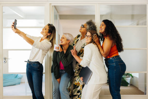 istock Multicultural businesspeople taking a group selfie in an office 1482848454