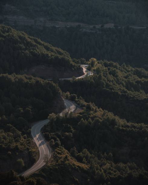 istock a road curves around a hill in a valley surrounded by trees 1482848619