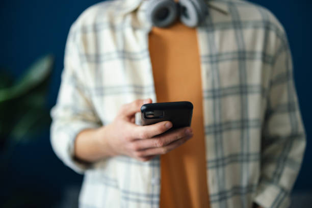 anonimowy mężczyzna stojący i korzystający z telefonu komórkowego - mobile phone bluetooth communication abstract zdjęcia i obrazy z banku zdjęć
