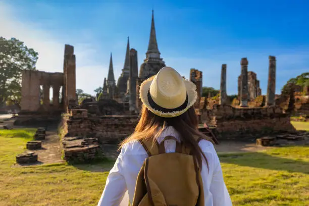 Back view of woman tourist come to visit at Wat Phra Si Sanphet temple, Ayutthaya Thailand for travel, vacation, holiday and tourism