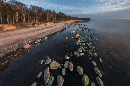 Landscape with sandstone cliffs, stony seaside of Vidzeme, Latvia. Photographed on a spring evening from drone.