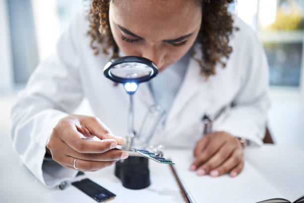 istock Hand, microchip and magnifying glass with an engineer woman at work in a laboratory for research or innovation. Science, computer chip or zoom with a female scientist in a lab to develop electronics 1482854503