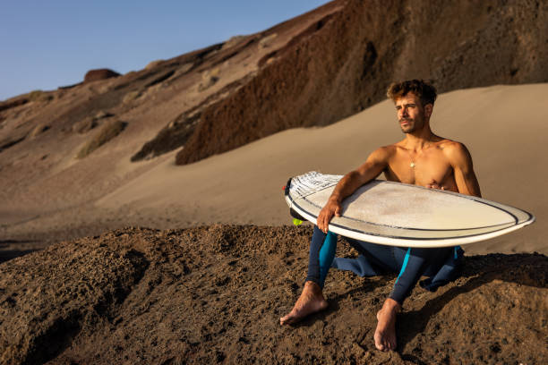 istock Smiling young man with surfboard on the beach. 1482858533