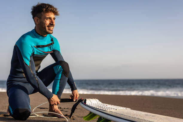 istock Smiling young man with surfboard on the beach. 1482858566