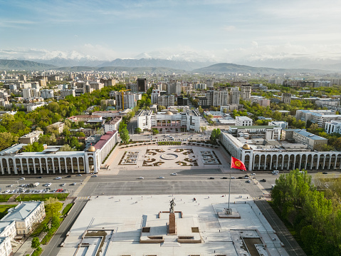 Aerial view of Bishkek city's Ala-Too central square with waving flag during spring