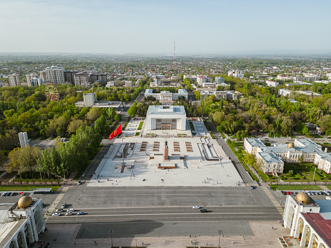 Aerial view of Bishkek city's Ala-Too central square with waving flag during spring