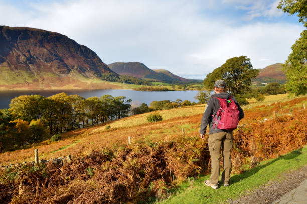 męski turysta cieszący się widokiem na jezioro crummock water, położone między loweswater i buttermere, w lake district w kumbrii, w północno-zachodniej anglii. - windermere district zdjęcia i obrazy z banku zdjęć