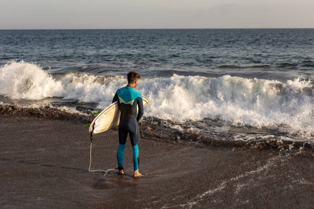 istock A surfer walks along a sandy beach and carries a surfboard in his hands 1482862318