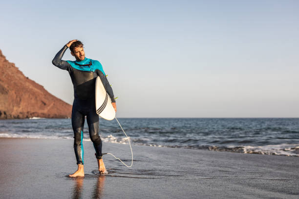 istock A surfer walks along a sandy beach and carries a surfboard in his hands 1482862343