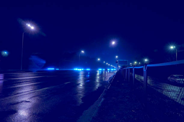 istock Night empty freeway highway  with wet asphalt and shining blue lights 1482865502