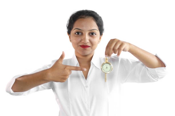Young woman in formal wear holding a vintage watch.
