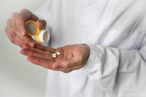 istock Pills in doctor's hand, white background 1482867105