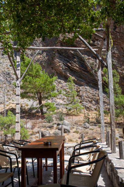 table and chairs set up on an open terrace in nature, overlooking a forest and mountains