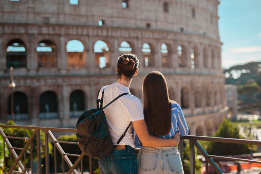 Male tourist hugging woman on waist, admiring historical building, Colosseum