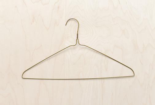 Closeup of a metal hanger on a wood background.