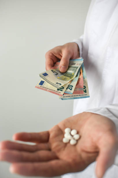 istock Pills and money in doctor's hand, white background 1482868497