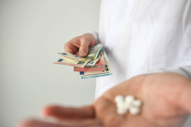 istock Pills and money in doctor's hand, white background 1482868502