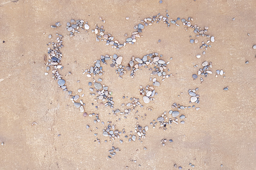 Pebble heart on sand. Love, valentine concept