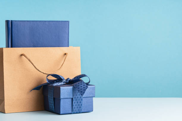 istock one gift box with a blue bow and paper bag on desk 1482869996