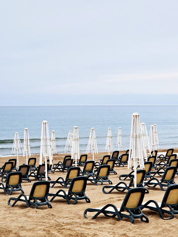 empty sandy beach with sun loungers and umbrellas