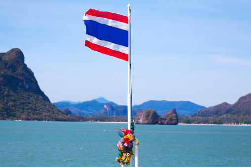 Coastline of Surat Thani behind thai flag