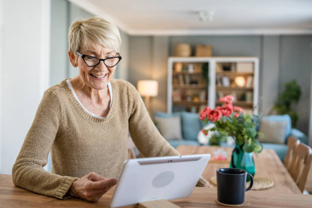 Senior woman caucasian female hold credit card online shopping at home stock photo