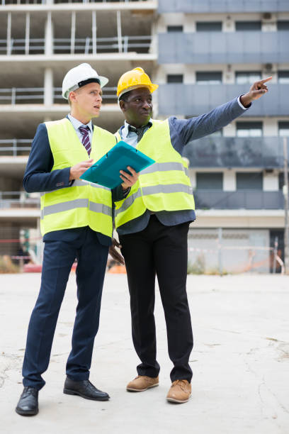 istock African-american engineer discussing a construction plan with a  colleague shows him something 1482875855
