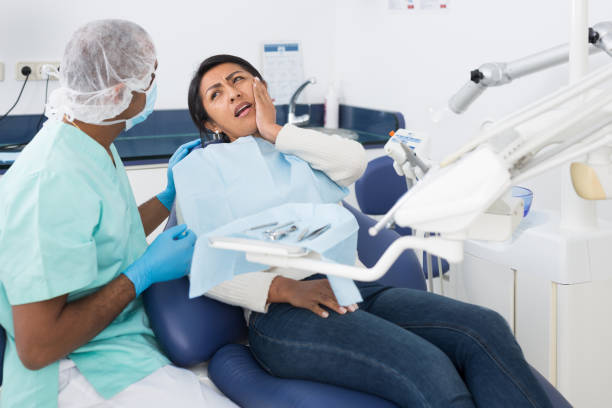 istock Latina suffering from toothache talking to stomatologist in clinic 1482876229