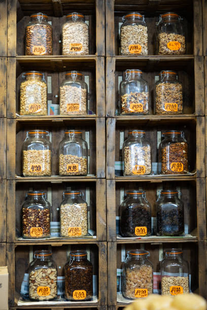 istock Glass jars with different nuts on grocery store shelves 1482877105