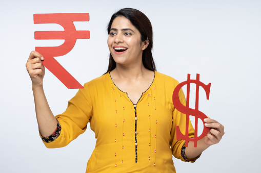 Portrait of young woman showing Dollar with Rupee sign in isolated white background