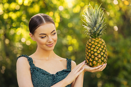 Beautiful girl enjoying pineapple