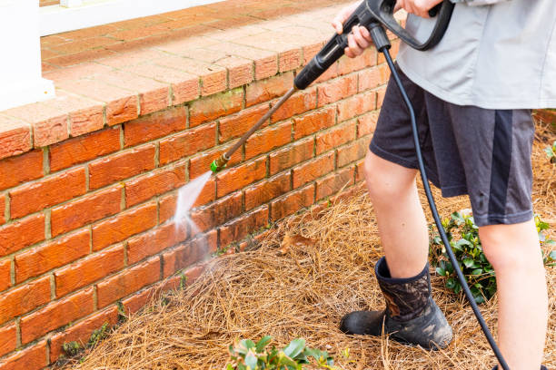 Brick surface being cleaned with water from a pressure washer. stock photo