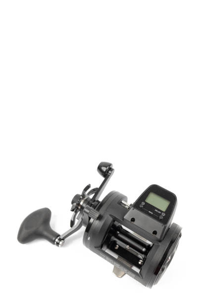 Black fishing reel baitcast isolated above white background stock photo