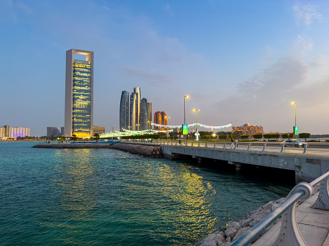 Modern skyline of Abu Dhabi downtown cityscape waterfront view in the United Arab Emirates at blue hour at the UAE capital