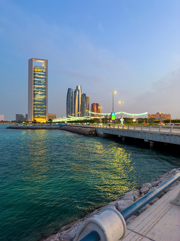 Modern skyline of Abu Dhabi downtown cityscape waterfront view in the United Arab Emirates at blue hour at the UAE capital